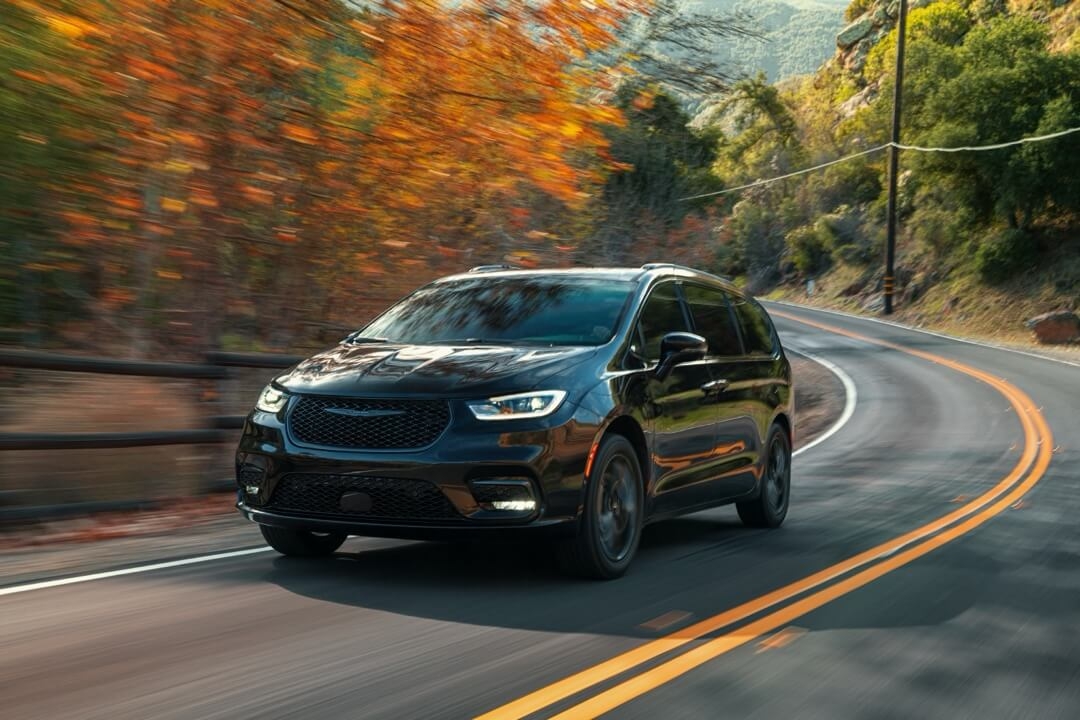 Vue 3/4 avant de la Chrysler Pacifica 2024 roulant à toute puissance sur une route.