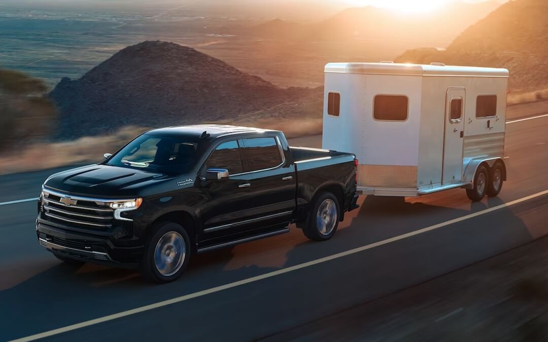 Le camion Chevrolet Silverado 1500 2024 remorquant une cargaison sur une route.