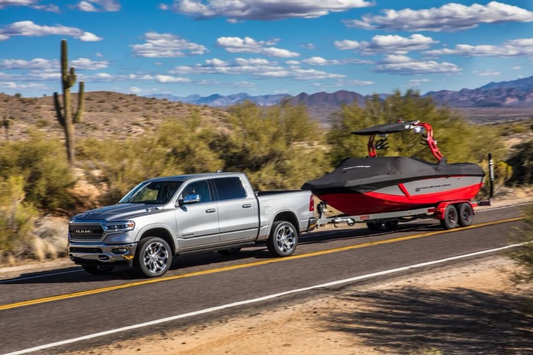 Vue latérale du RAM 1500 2024 remorquant un bateau.