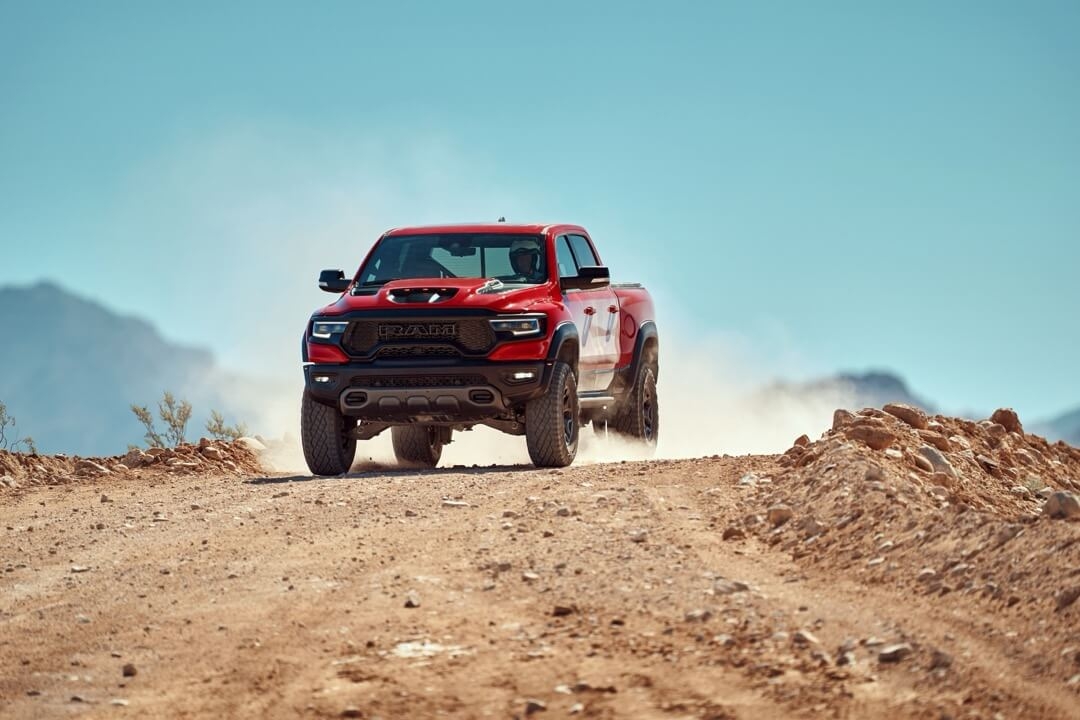 Le camion RAM 1500 TRX 2024 roulant sur un chemin de sable.