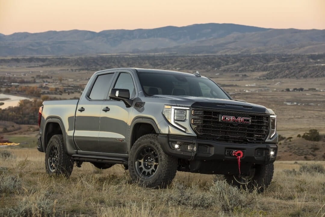 Vue 3/4 avant du GMC Sierra 1500 2024 garé sur une terre en nature.